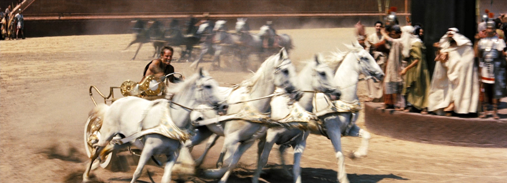 Photo of Charlton Heston as Judah Ben-Hur in the iconic chariot race.