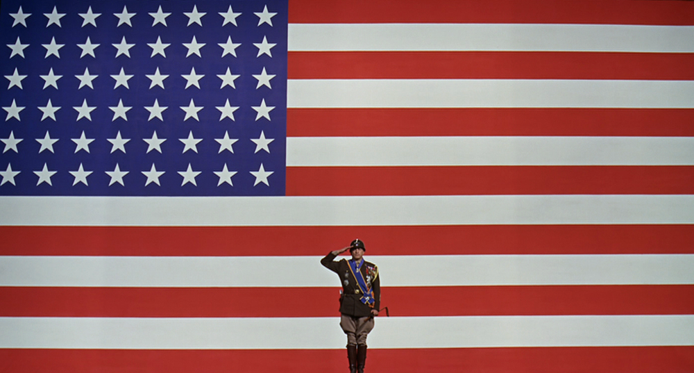 Image of George C. Scott in front of the flag.
