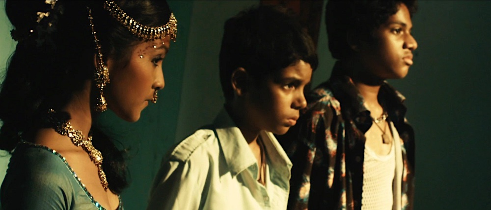 Photo of Tanvi Ganesh Lonkar as Latika, Tanay Chheda as Jamal, and Ashutosh Lobo Gajiwala as Salim.