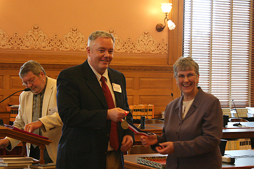 Paul Miles Schneider receives his medal from Jo Budler, the State Librarian of Kansas, as author of "Silver Shoes," one of the 2010 Kansas Notable Books.
