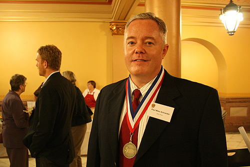 Paul Miles Schneider proudly wears his medal for "Silver Shoes" at the 2010 Kansas Notable Books awards reception.