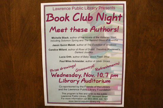 A Book Club Night flyer posted on a library wall.