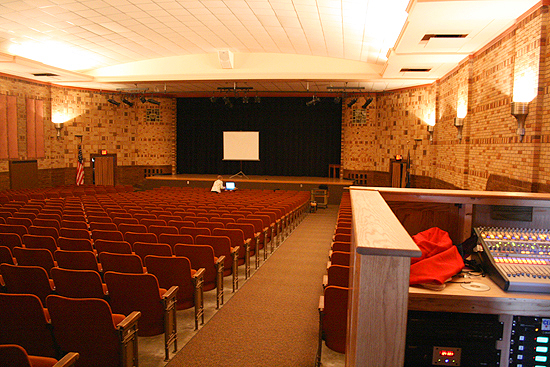 Linda Glaze sets up the projector at the front of the auditorium for my speech to the student body in Oberlin, Kansas.