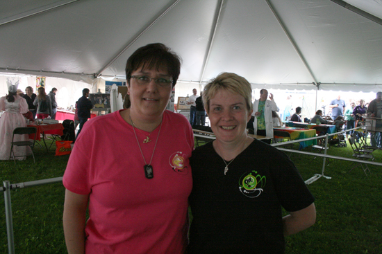 Oz-Stravaganza! co-chair Barbara Evans and committee member Lynne Bunce in Glinda's Royal Tent proudly wear the "good witch" and "bad witch" T-shirts designed by fellow committee member Dennis Kullis.