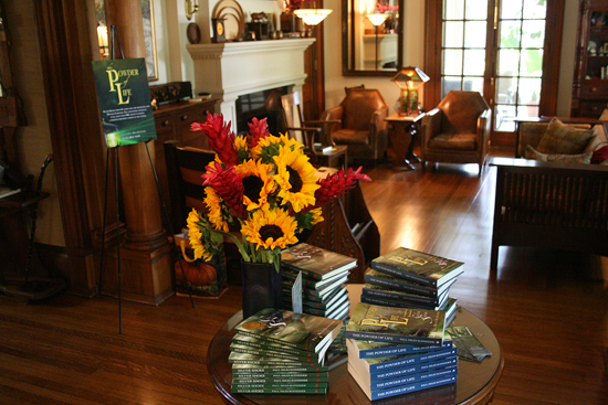 Copies of "Silver Shoes" and "The Powder of Life" are displayed on the front hall table of Jane Albright's home. The cozy and elegant room where the reading took place is seen behind it.