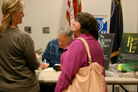 Paul Miles Schneider signs copies of his latest novel, "The Powder of Life," at the Lawrence Public Library on October 18, 2012.