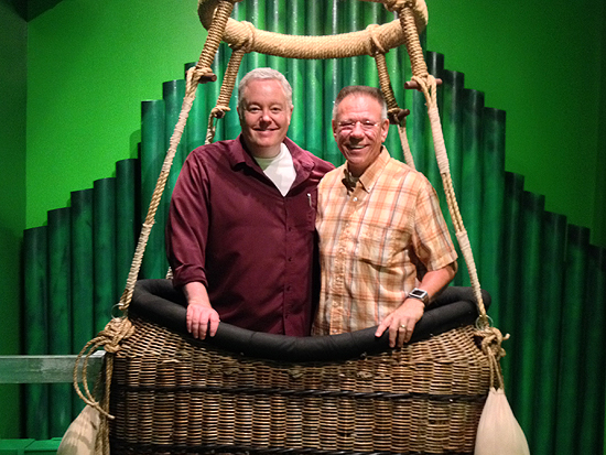 Paul Miles Schneider poses in the Wizard's balloon with JohnPaul Cafiero, owner of the huge collection on display at the Oz Museum. Wamego, Kansas. 2013.